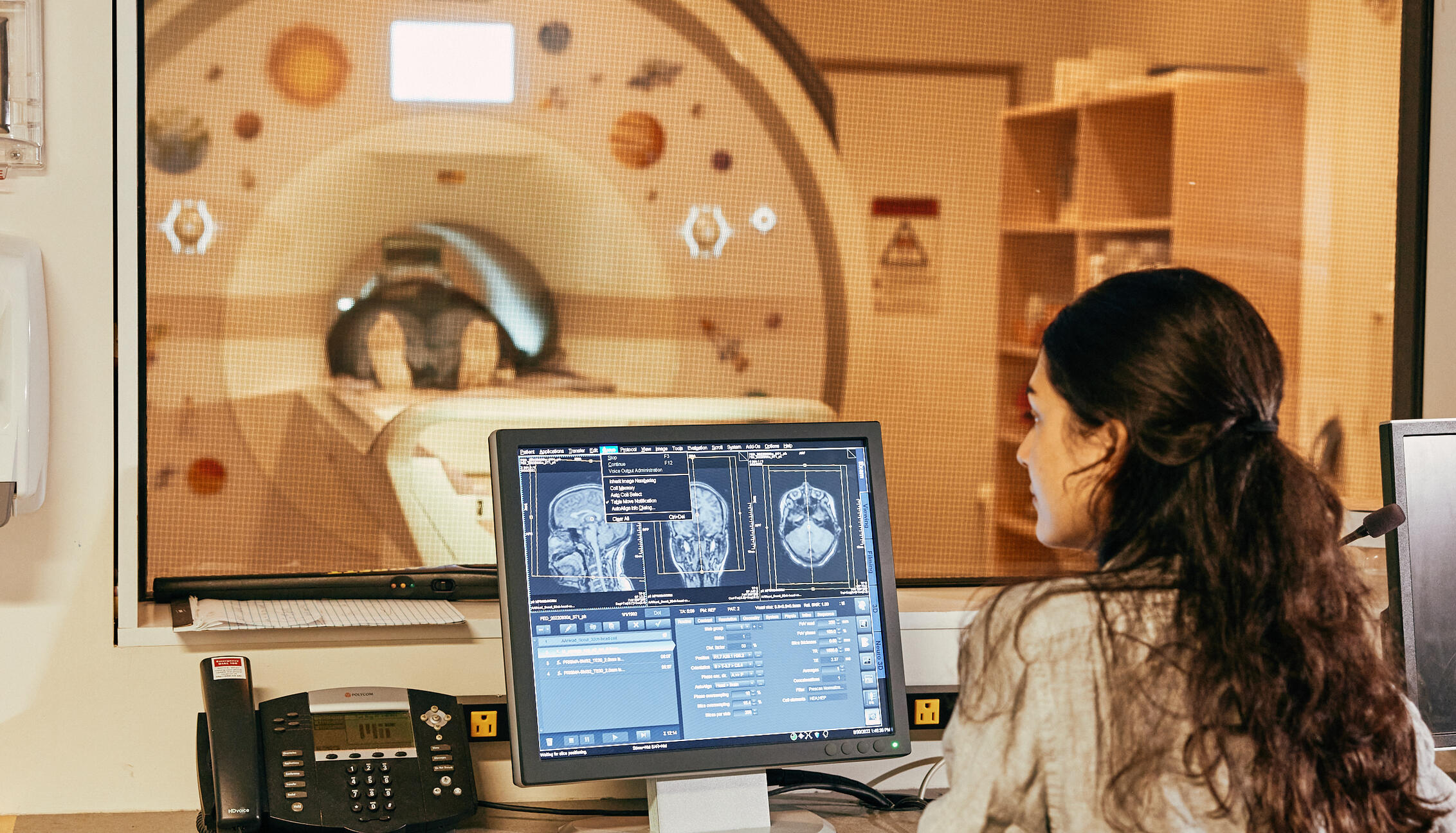 Student Looking at MRI Scan with MRI machine in the background