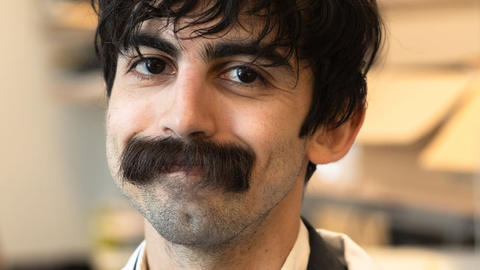 portrait of man with dark hair and mustache smiling