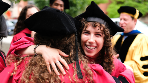 Two graduates hugging